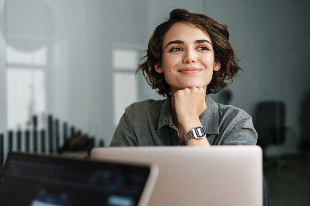Woman smiling while working with laptop