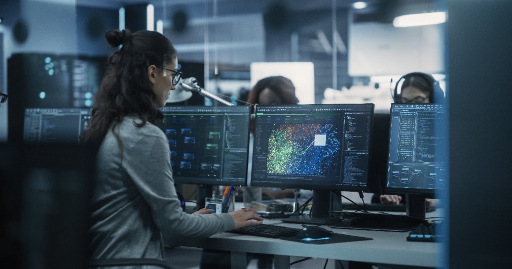 Government personnel reviewing data on a monitor