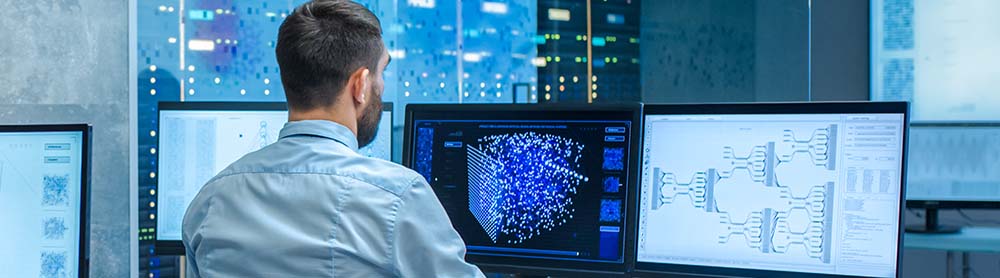 Consultant working on several computer screens