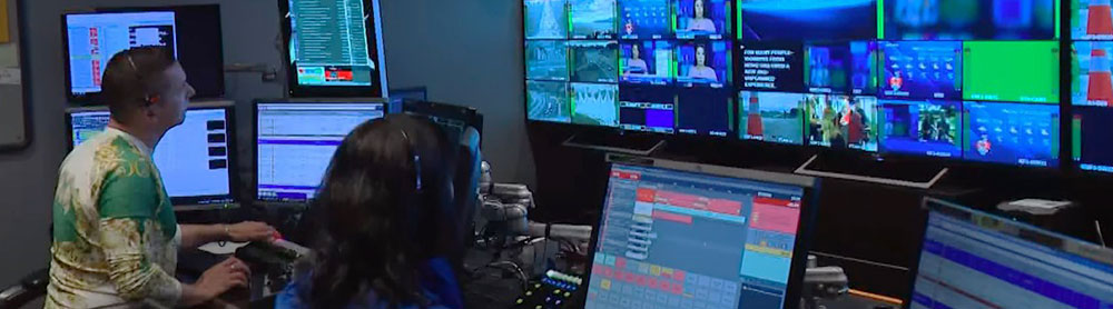 Two professionals looking at monitors in broadcasting studio