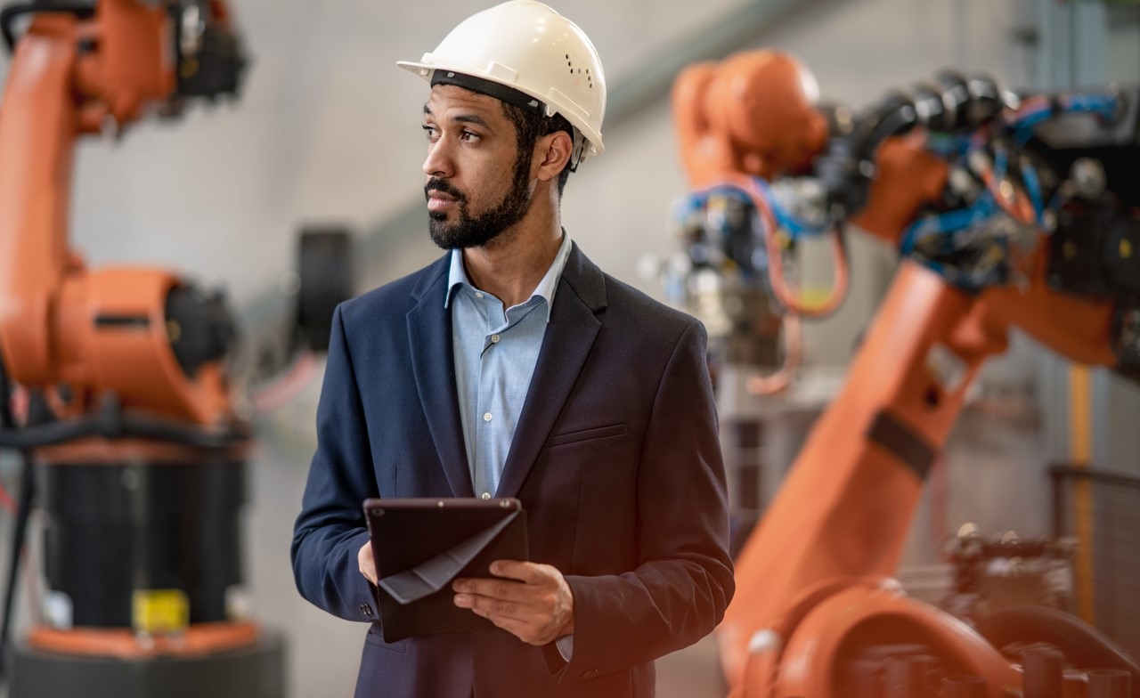 Engineer wearing a hardhat holding a tablet