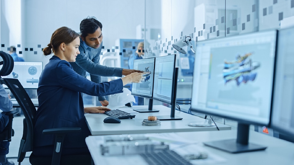Colleagues in technical setting looking at SAP S/4HANA on computer screen