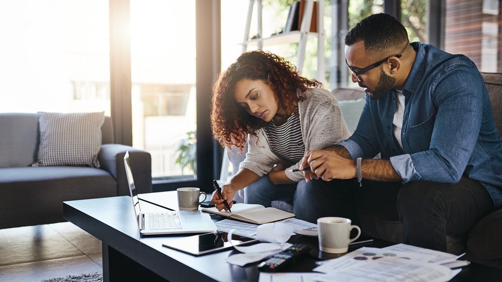 Financial review of spending with a man and woman writing in a notebook