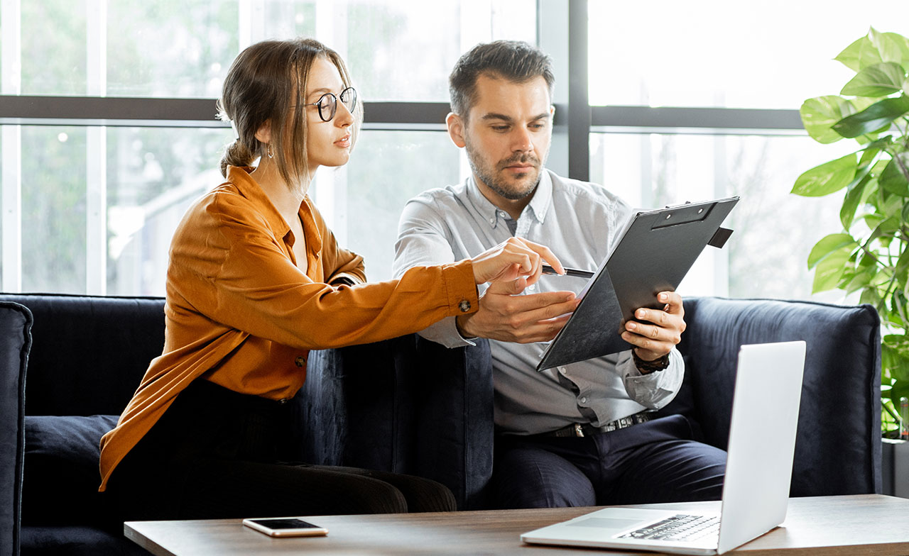 Two people reviewing data on a clipboard