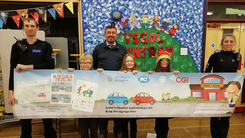Children and police officers holding a banner