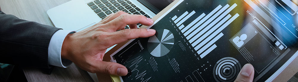 Person sitting at a desk looking at graphs and statistics