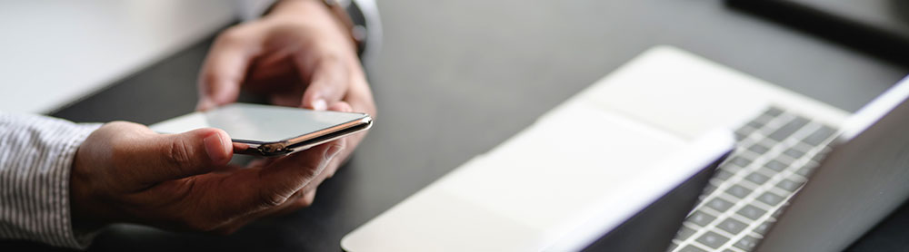 Person holding a phone next to office hardware