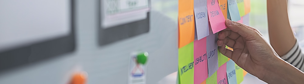 Person placing post its on a board
