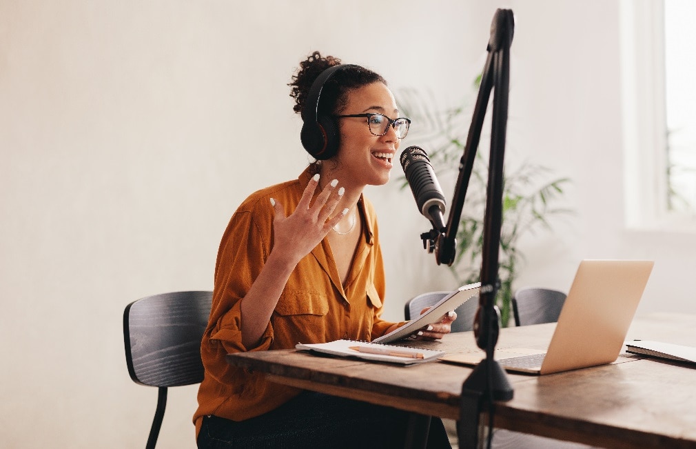 Student wearing headset and talking into microphone in front of laptop