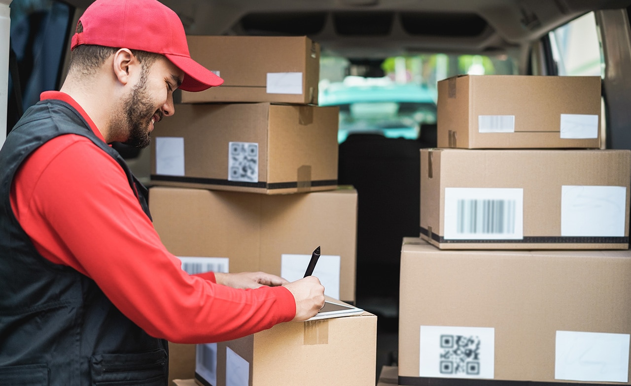 Courier man signing on tablet for delivery boxes