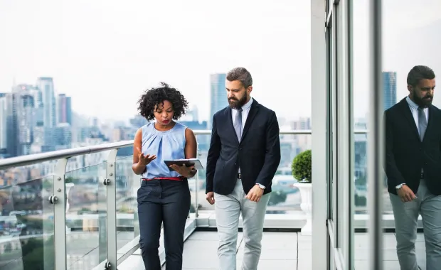 Two colleagues walk outside office discussing cyber risk