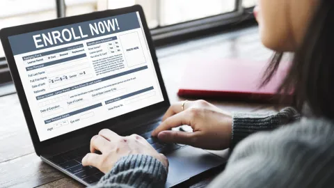 Woman using laptop to enroll in health insurance