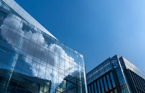 glass building with cloud reflected in the windows