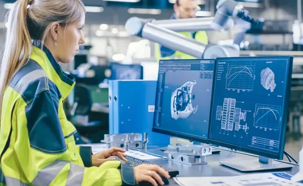 factory worker looking at digital twin on monitor