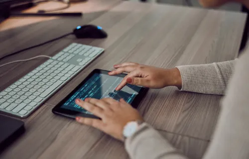 Frau programmiert etwas via Tablet