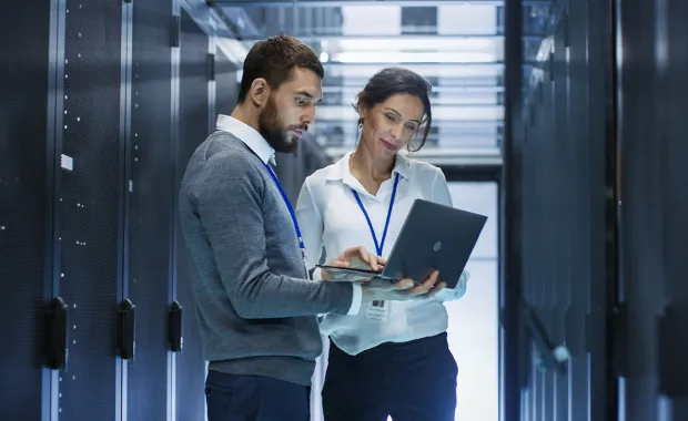 Consultants looking at alaptop in a cloud data center