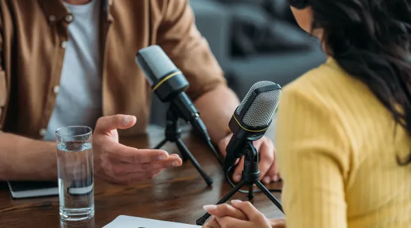 Two people recording their conversation through microphones