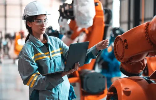 Robotic engineer using laptop for robot maintenance