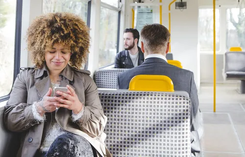 Train passenger uses mobile device