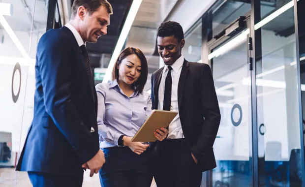 professionals gathered together looking down at a notebook